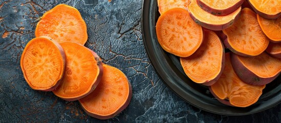 Poster - Vibrant orange sweet potato slices arranged artistically on a dark textured background with ample copy space for culinary or health themes