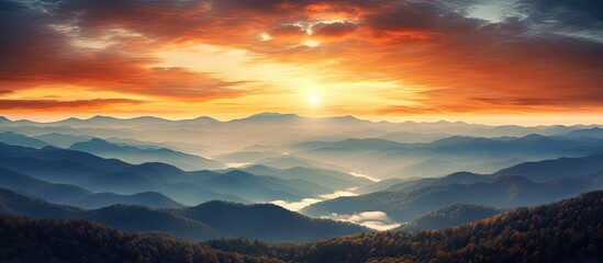 Aufkleber - Vibrant sunset over layered autumn forest mountains highlighting deep oranges and blues with tranquil water reflections in the valleys below.