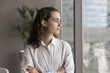 © fizkes - Thinking about future. Head shot serious thoughtful millennial girl young leader student employee stand by window look at distance visualize career plans set professional goals seek new work challenge
