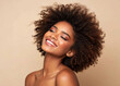 © Sain - Beauty portrait of african american girl with clean healthy skin on beige background. Smiling dreamy beautiful black woman.Curly hair in afro style