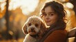 © MK studio - A young woman enjoys a sunny afternoon in the park with her fluffy poodle relaxing on a bench surrounded by autumn foliage