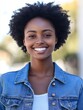 © Johannes - Happy African young woman wearing denim jacket laughing looking at camera standing on street. Smiling Afro American teen generation z hipster girl posing outdoor backlit with sunlight, portrait.