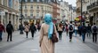 © Sasa Visual - A woman in hijab strolls down a bustling European city street, surrounded by people going about their day. A peaceful scene of everyday life
