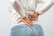 © TSViPhoto - Woman grabbed his lower back. Radiculitis symptom, inflammation, pain in the spine