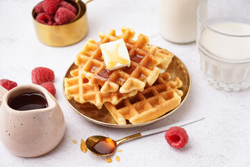 Wall Mural - Plate of tasty waffles with raspberries and maple syrup on white background