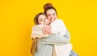 © DMegias - Two happy friends hugging and having fun on yellow background