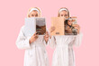 © Pixel-Shot - Happy young woman and her mother in bathrobes with magazines on pink background