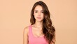 © KarpenArt Studio - Young woman with long brown hair and pink tank top posing in front of beige background.