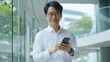 © kiki__ - Confident asian businessman using smartphone in modern office space