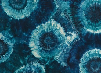 Wall Mural - A close-up of tie-dye fabric with shades of blue and green, creating an abstract pattern that resembles clouds or water ripples. The background is dark teal to accentuate the details of each tie-dye