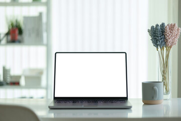 Wall Mural - comfortable workspace laptop with a blank screen, a coffee cup, and a decorative glass vase with flo