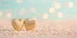 © Gentle Bunny - Two golden hearts sit on a sandy surface, surrounded by a soft bokeh background, evoking feelings of love and warmth.