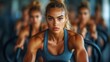 © kinkin - Focused woman in fitness class, intense workout.
