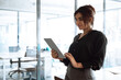 © Stock 4 You - Young smiling middle eastern businesswoman using tablet pc app standing in office. Indian or latin hispanic business woman holding digital computer. Manager or financial specialist working on project