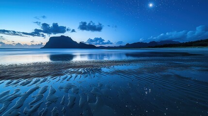 Wall Mural - Serene twilight beach landscape with mountain silhouette and starlit sky reflecting on calm water.