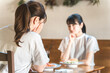 © buritora - カフェでランチをしながら悩み相談を友達にする若いアジア人女性
