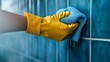 © MKS - A bathroom tile wall is scrubbed clean of dirt and grime by a gloved hand with a blurred edge