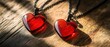 © Fernando - Two red heart shaped pendants with black chain on rustic wooden surface in warm sunlight, concept of love, romance, and Valentines Day