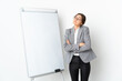 © luismolinero - Young Ireland woman isolated on white background giving a presentation on white board and making doubts gesture