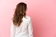 © luismolinero - Middle aged caucasian woman isolated on pink background in back position and looking side