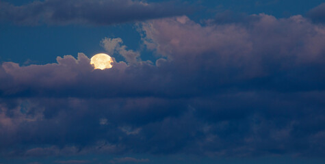 Wall Mural - full moon with yellow behind the clouds