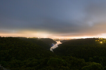Wall Mural - Cloudy landscape of tree and river at dawn.