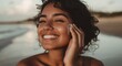 © jannik27s - portrait of a beautiful young, smiling Hispanic woman applying sunscreen on her face at the beach