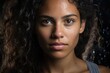 © Pavel Lysenko - Portrait of a young woman with curly hair and an intense gaze against a dark backdrop