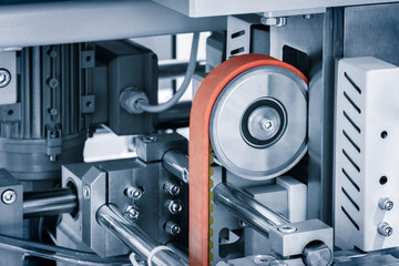 Aufkleber - A machine with a belt is shown. The belt is made of rubber and is used to transfer materials. The machine is in a factory setting and is surrounded by other machines