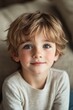 © Bojan - Young boy with light brown hair and blue eyes gazing thoughtfully indoors