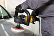 © New Africa - Man polishing car hood with orbital polisher indoors, closeup