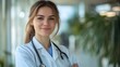 © AdorStudios - smiling female doctor with stethoscope standing in a medical office showing trust professionalism and dedication to patient care and well being