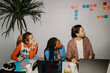 © Maskot - Male and female business professionals looking away while sitting at desk during meeting at office