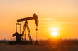 © A2Z AI  - Silhouette of an oil pump jack at sunset, a symbol of energy production against a bright orange sky. Industrial landscape at dusk.