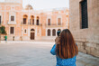 © mdyn - Photographer with a professional camera takes pictures on urban background. Traveler 30s woman visiting Valencia Cathedral. Summer Holidays in Spain. Female is exploring city. Top tourist attraction