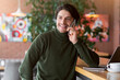 © Prostock-studio - Handsome man freelancer working with laptop at cafe, talking on phone with clients, free space