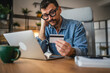 © Miljan Živković - exhausted and tired businessman buy online on laptop and credit card
