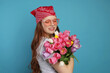 © New Africa - Beautiful teenage girl with bouquet of tulips on light blue background