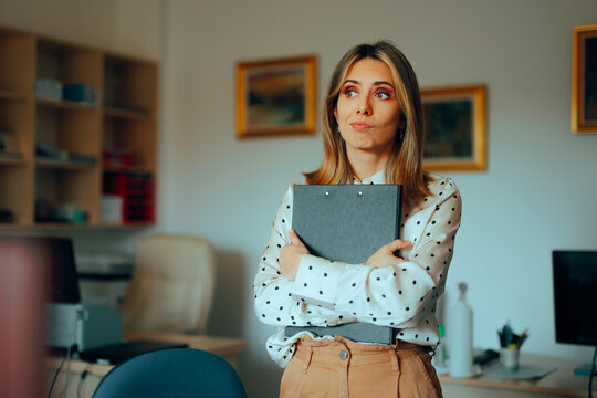Stressed Woman Holding a Clipboard in an Office. Unhappy employee feeling annoyed by all the bureaucracy 
