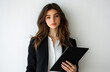 © top  success - Young professional woman in a black blazer holding a tablet, standing against a neutral background