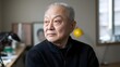 © thanarak - Close up portrait of a reflective sorrowful looking elderly East Asian man with a thoughtful meditative expression captured in soft natural indoor lighting in an office or workplace setting