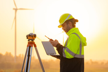 Aufkleber - Engineer working on laptop in front of wind turbines for checking wind turbines of the field during beautiful sunset. Alternative energy concept.