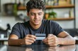 © duyina1990 - Young Man Examining a Credit Card in a Home