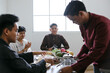 © Gatot - Asian Muslim Man Serving Drinks For His Friends To Break Fasting Together During Ramadan Kareem at Home