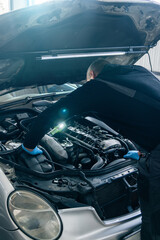 Fototapete - Serviceman repair car in car service