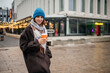 © Westend61 - Woman walking in the city holding coffee during autumn