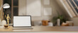 © bongkarn - A white screen laptop on wooden table under the lamp light and moon light. Study or working at night.