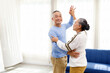 © artitwpd - Asian senior couple dancing happily in a bright home, enjoying an active lifestyle, love, and togetherness. Perfect concept for aging gracefully, wellness, retirement, romance, and happiness.