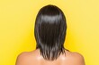© VICHIZH - Woman with wet long hair facing yellow background, highlighting healthy hair care and beauty routine, emphasizing vibrant color and sleek style