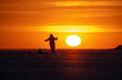 © ivan - Fishermen on a frozen lake at sunset. Big sun